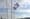 hellblaue Flagge mit einer weissen Taube vor blauem Himmel