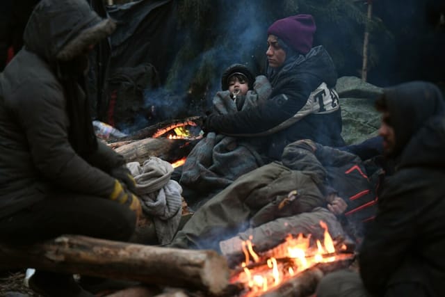 Weißrussland Polen Grenzflüchtlinge 6696000 15.11.2021 Flüchtlinge wärmen sich um ein Feuer in einem Migrantenlager an der we