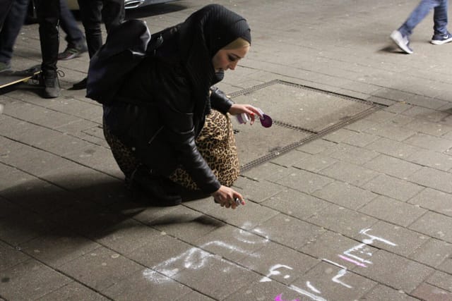 Salma sprüht Slogans auf den Steindamm. Foto: