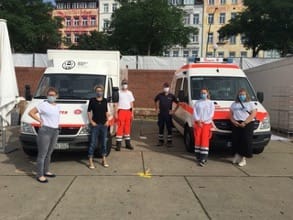 Das Women's Health Team steht vor Einsatzfahrzeugen