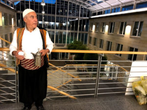 Ein Mann in traditioneller syrischer Kleidung hält eine Kanne Mokka