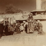 Eine Sepia-Fotografie mit erwachsenen Männern und Bacha Bazi