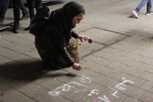 Salma sprüht Slogans auf den Steindamm. Foto: