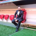 Mokki sitzt neben dem Spielfeld auf dem Trainerstuhl