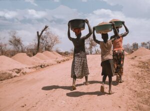 Frauen tragen Lebensmittel in einem Flüchtlingscamp in Uganda, Hungerkrise